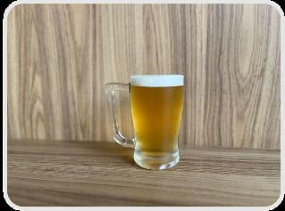 Caneca de chopp claro com colarinho, sobre a mesa de madeira