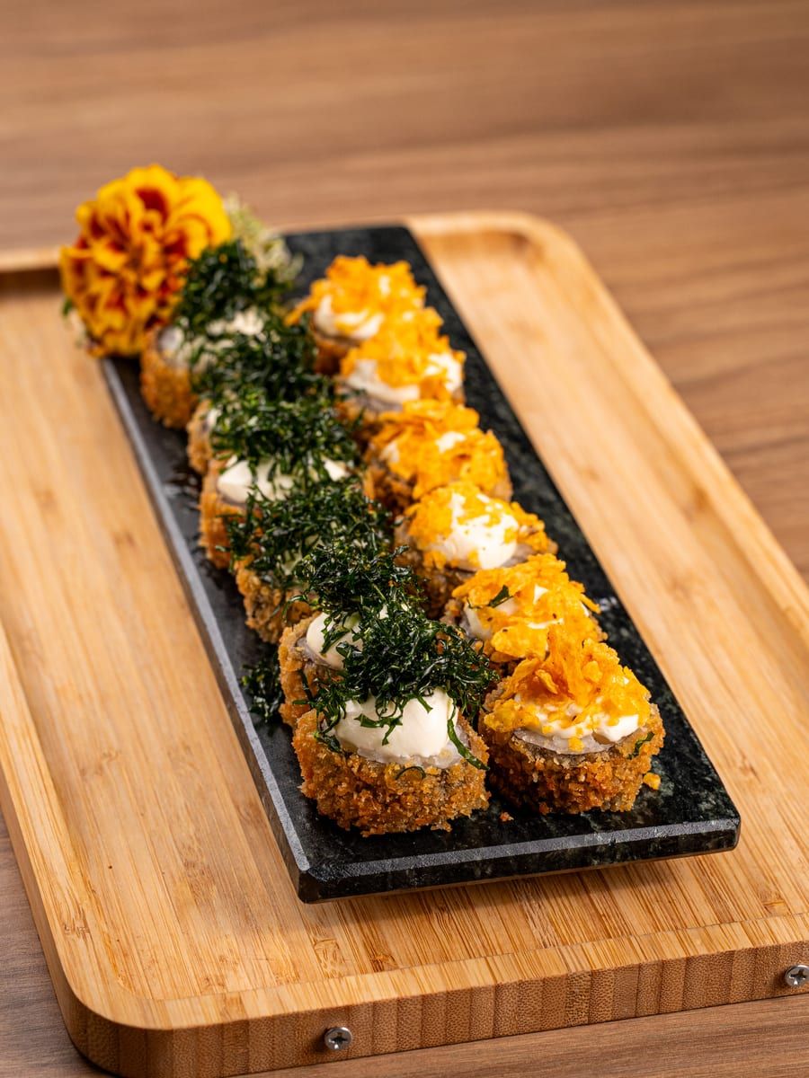 Hot rolls empanados cobertos por crispy de couve e crispy de batata-doce