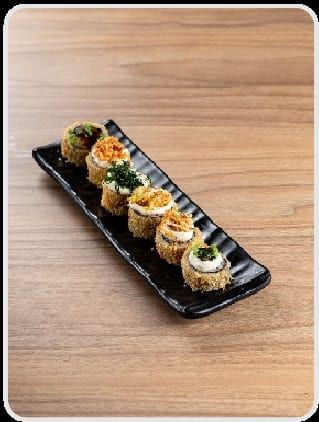 Fileira de hots empanados na travessa preta, com cream cheese, crispy verde e crispy dourado por cima