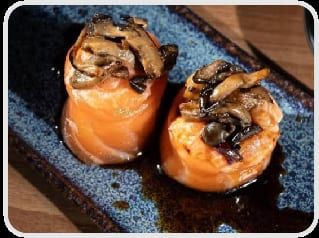 Dois joys enrolados em salmão com cogumelos shimeji salteados e molho escuro por cima