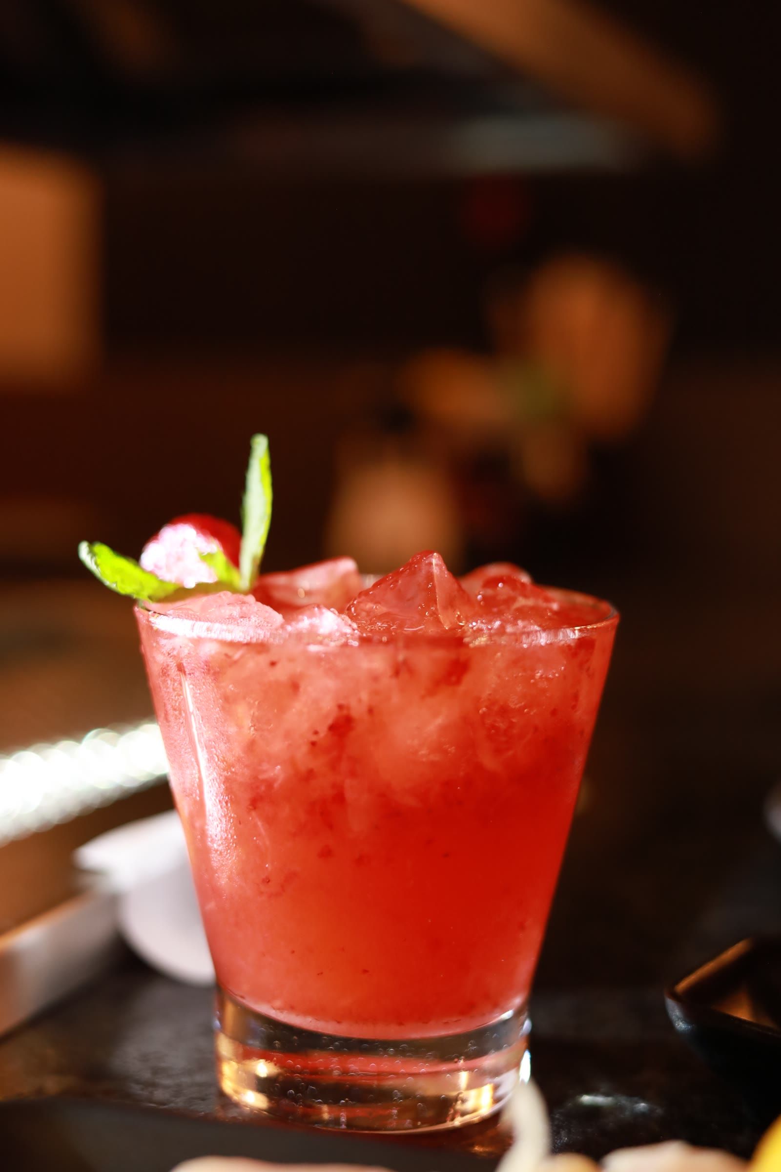 Drink de morango com hortelã e gelo triturado, servido em copo baixo