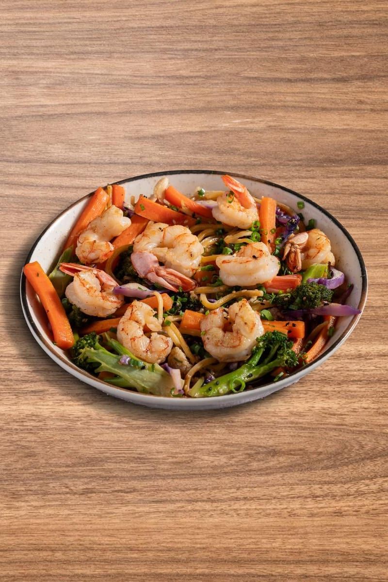 Yakissoba com camarões inteiros, pimentão e cenoura, em bowl de metal
